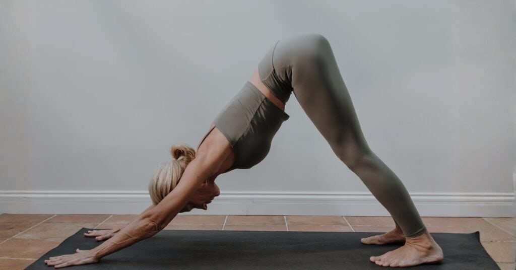 Woman performing yoga downward dog pose in non toxic leggings