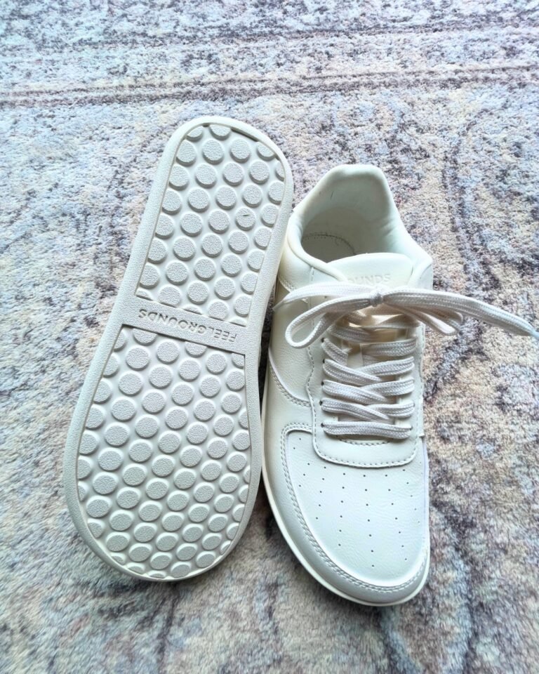 White barefoot shoes on patterned carpet.