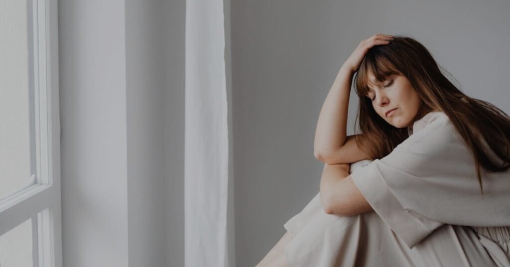 Cortisol and Perimenopause Why Stress Hits Different After 40 (And What Actually Helps) a woman on a window